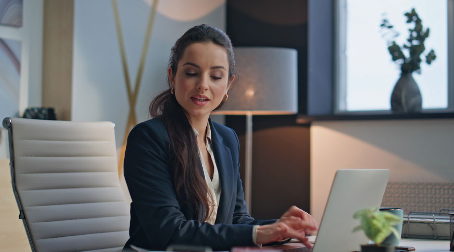 Advogada usando o Claude no notebook ao lado de documentos confidenciais